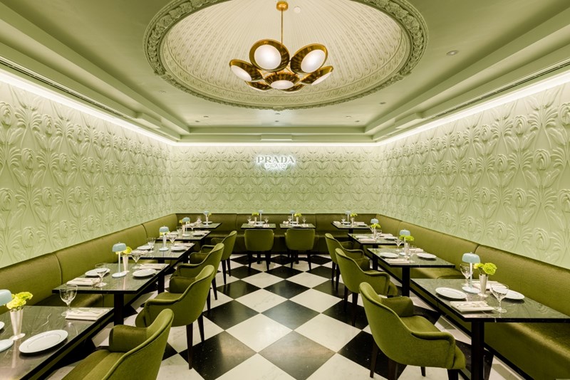 sala_tou_cafe_prada_me_fystiki_toixous_prasines_karekles_mavra_marmarina_trapezia_kai_floral_gypsina_stous_toixous